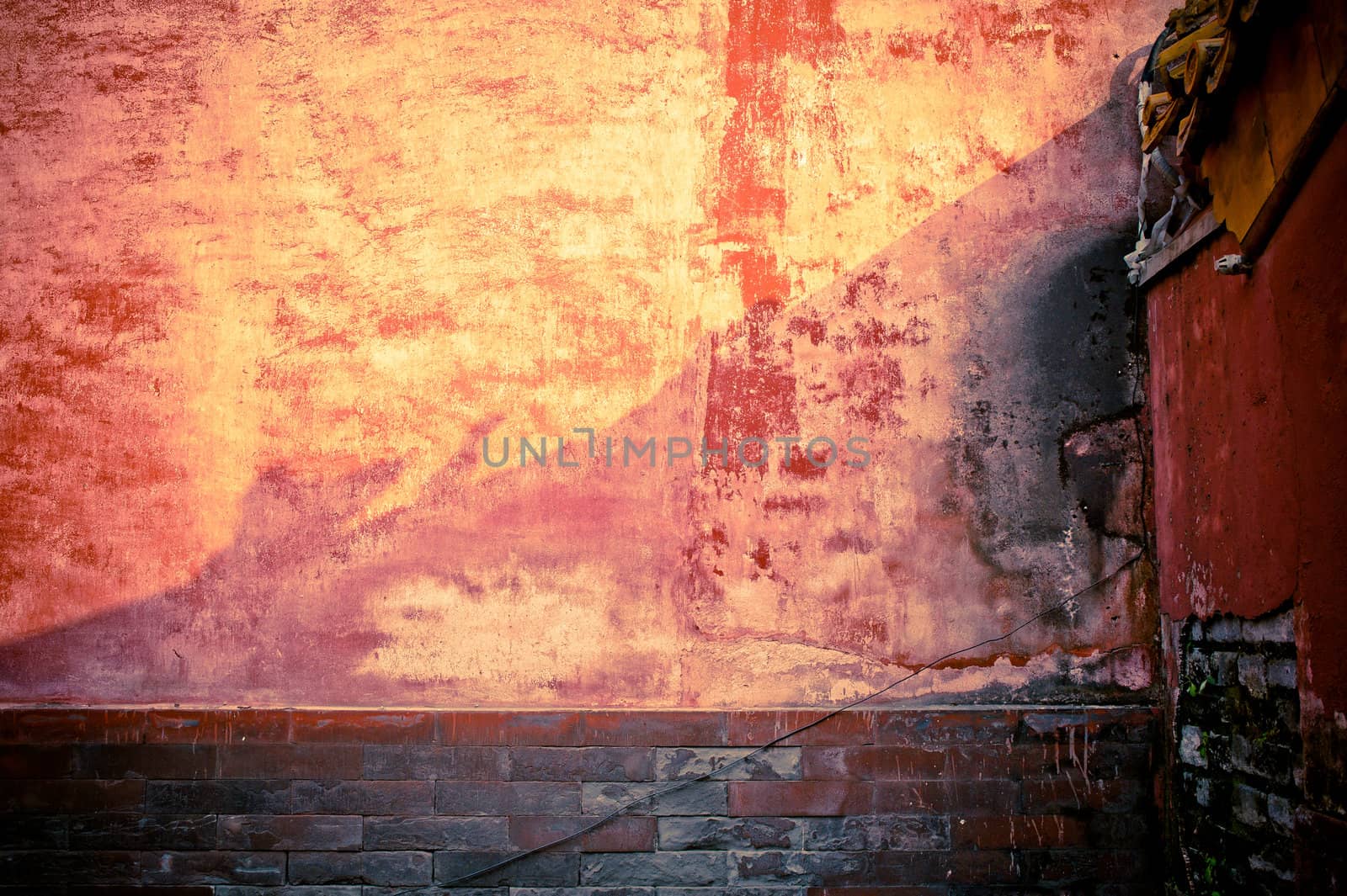 A weathered stone wall, in red tint.