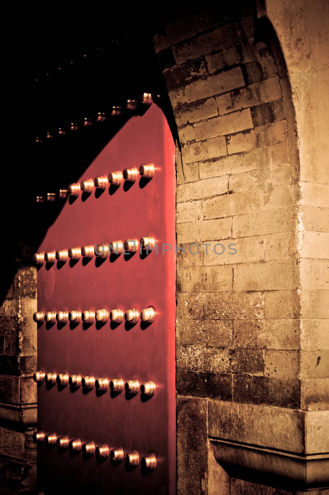 A red gate beneath an arched entry into the Imperial Palace in Beijing, China.