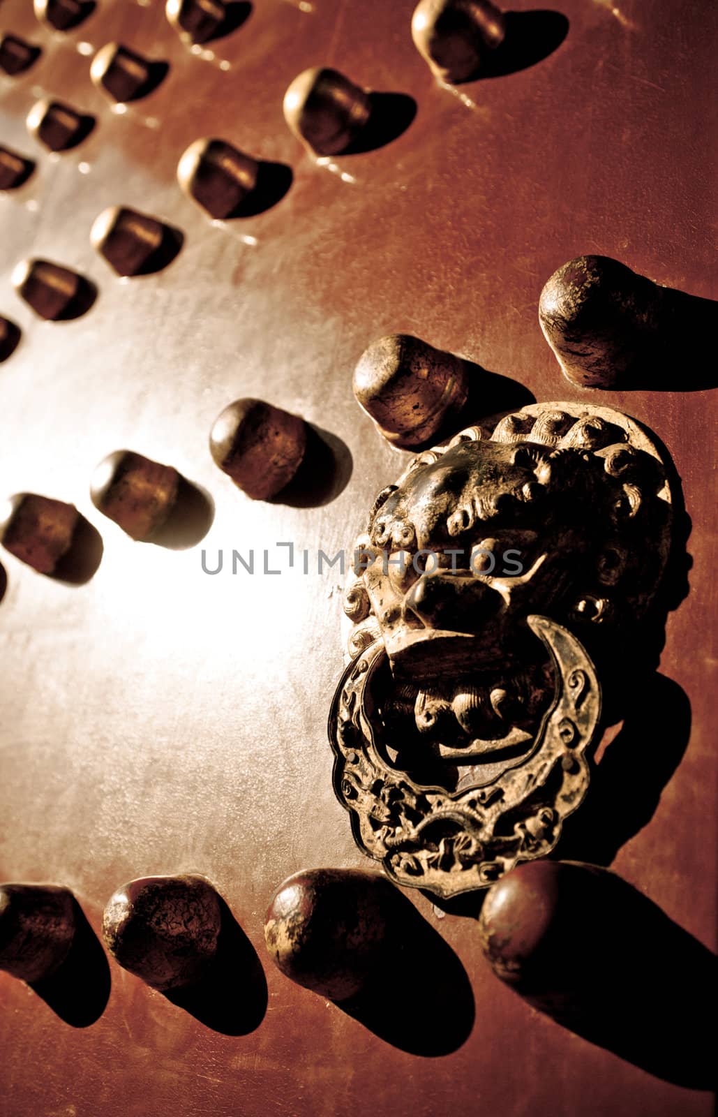 Lion door handle on a red door in the Imperial Palace.