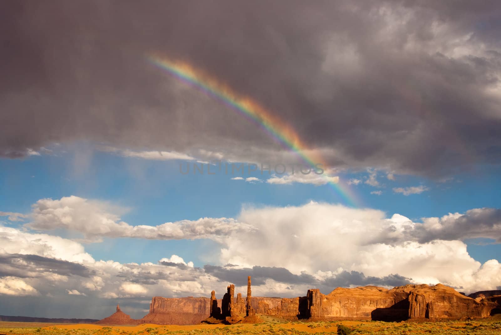 Rainbow and sunlight brighten Monument Valley after the storm