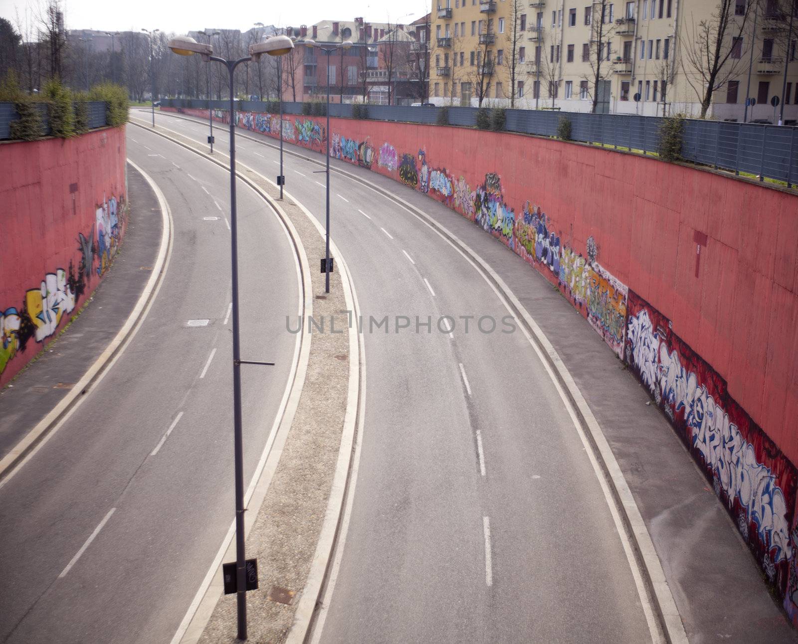 View of a road with graffiti on the wall