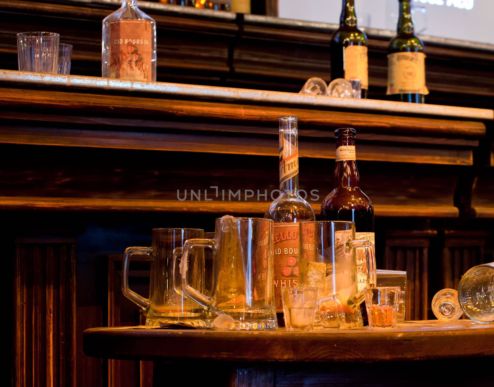 Photo of whiskey Bottles and glasses on desk