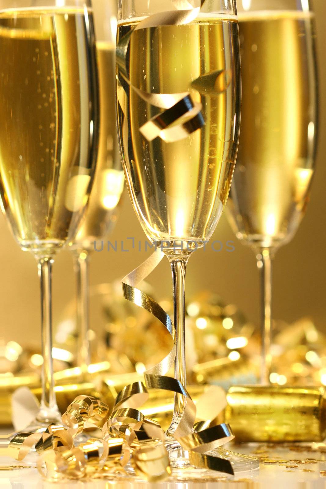 Golden champagne sparkle with fluted glasses and party ribbons