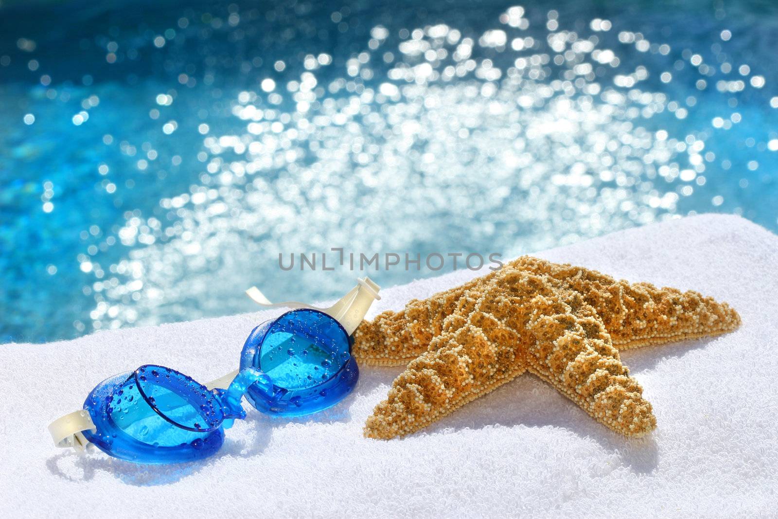 Under water goggles with starfish on a white towel