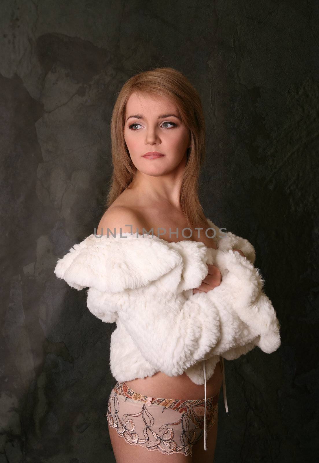 Portrait of the fine woman in underwear and a fur coat