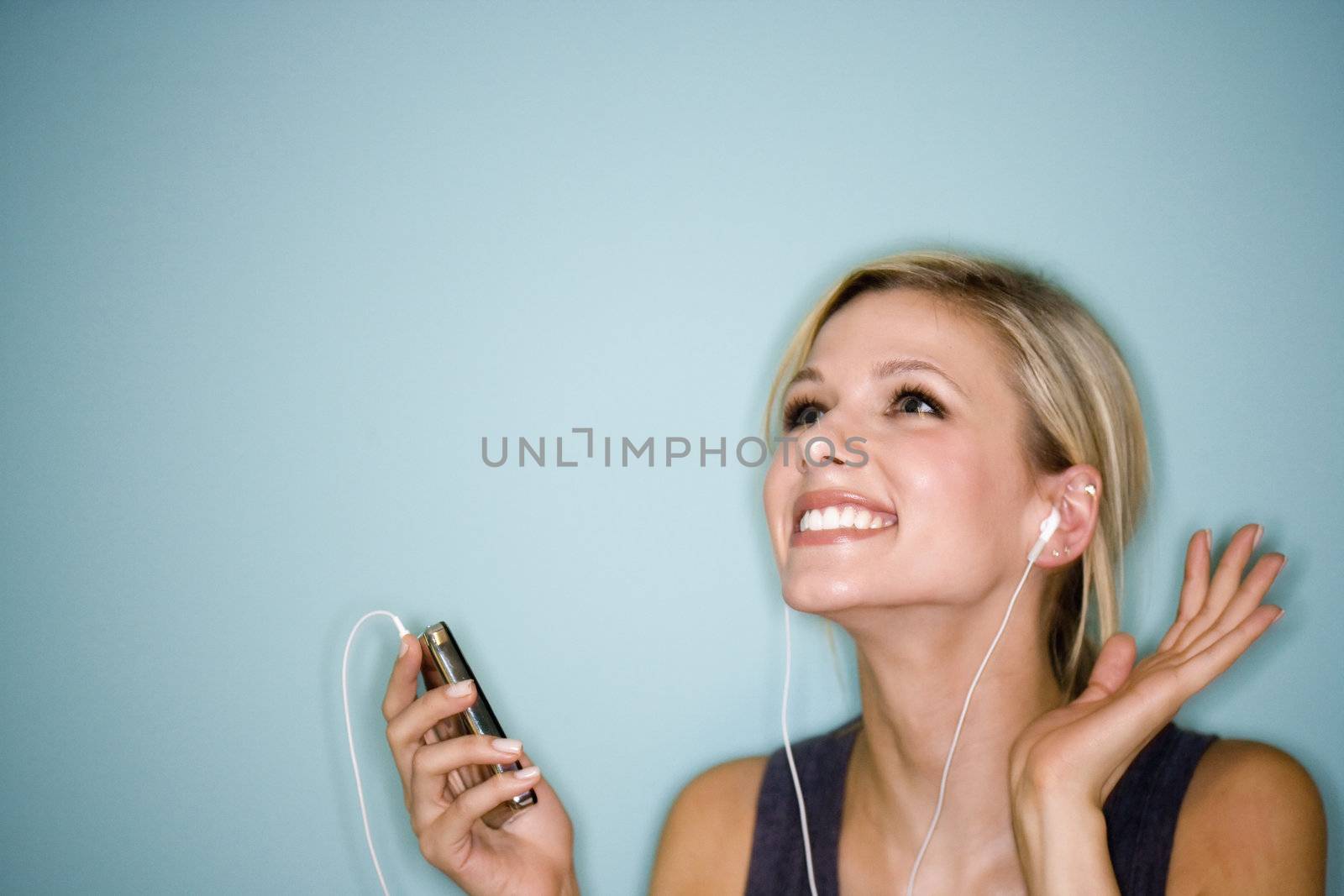 Woman listening to MP3 player by edbockstock