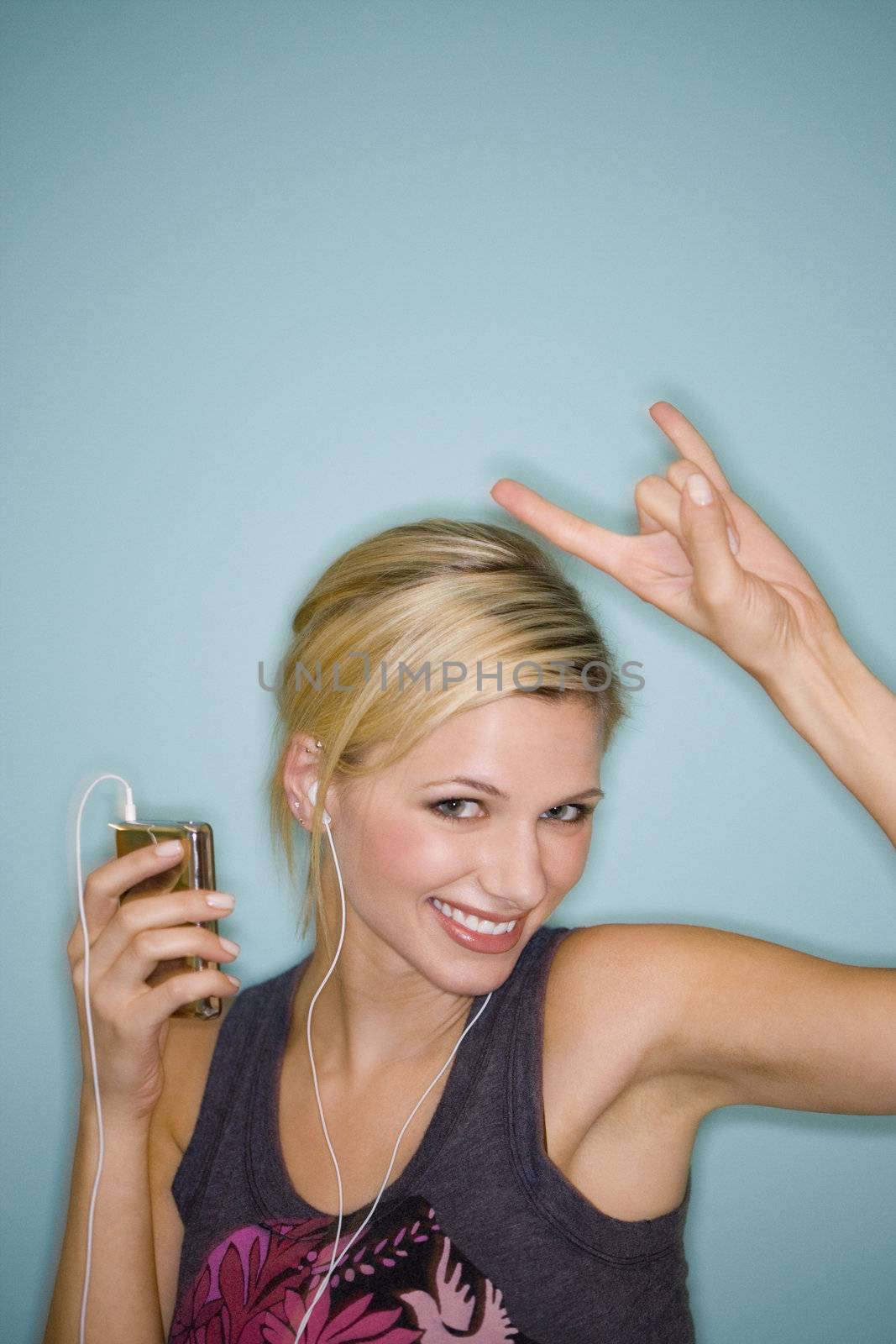 Smiling pretty woman with earbuds listening to MP3 player