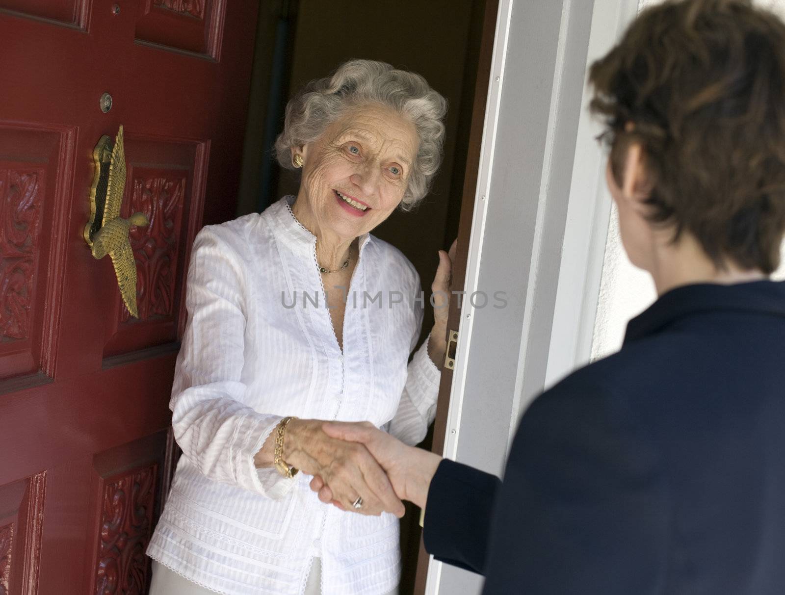 Senior woman friendly handshake by edbockstock