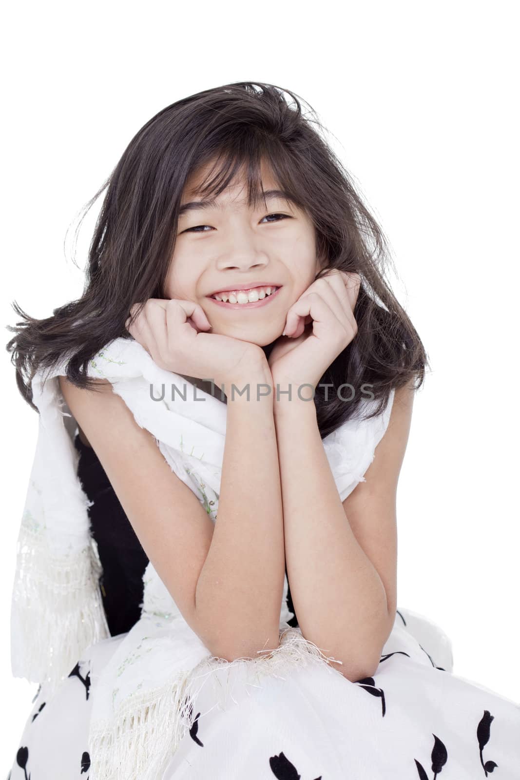 Young biracial asian girl in bkack and white formal dress, sitting and smiling, chin on hand