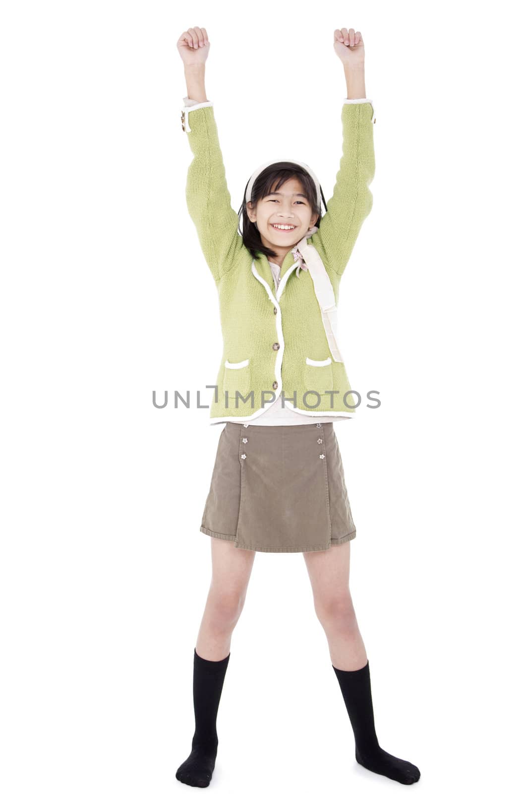 Girl in green sweater and skort standing with arms rasied, happy by jarenwicklund