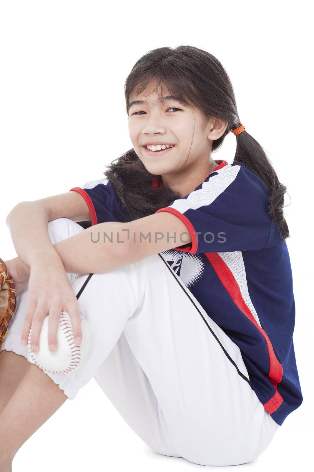 Biracial asian girl holding softball and glove while sitting, isolated