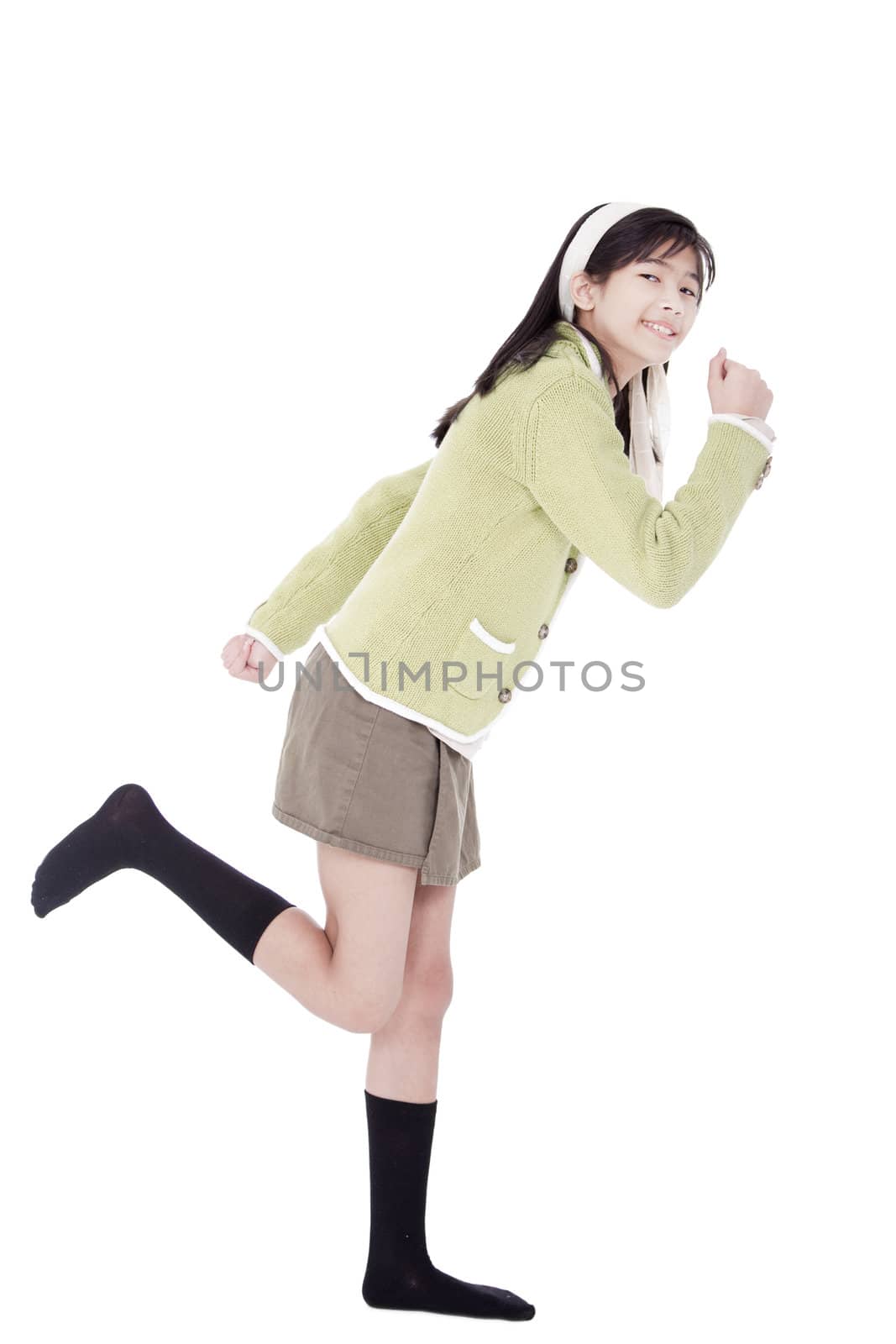 Girl in green sweater and skort in running position, isolated by jarenwicklund