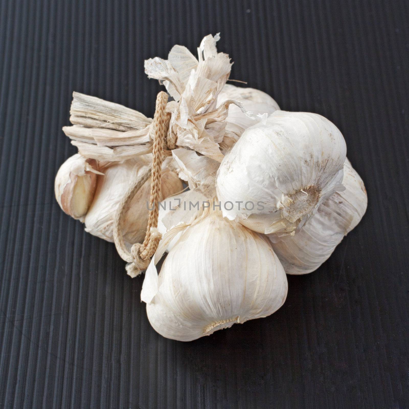 Some garlic heads over a black background