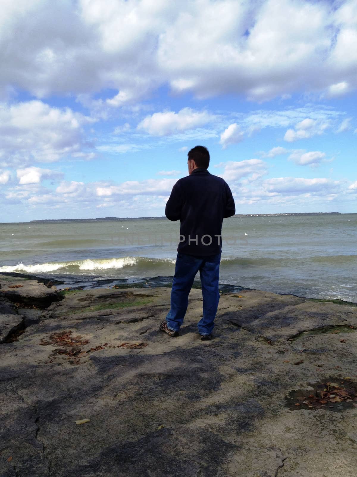 Man looks out at Lake Erie by RefocusPhoto