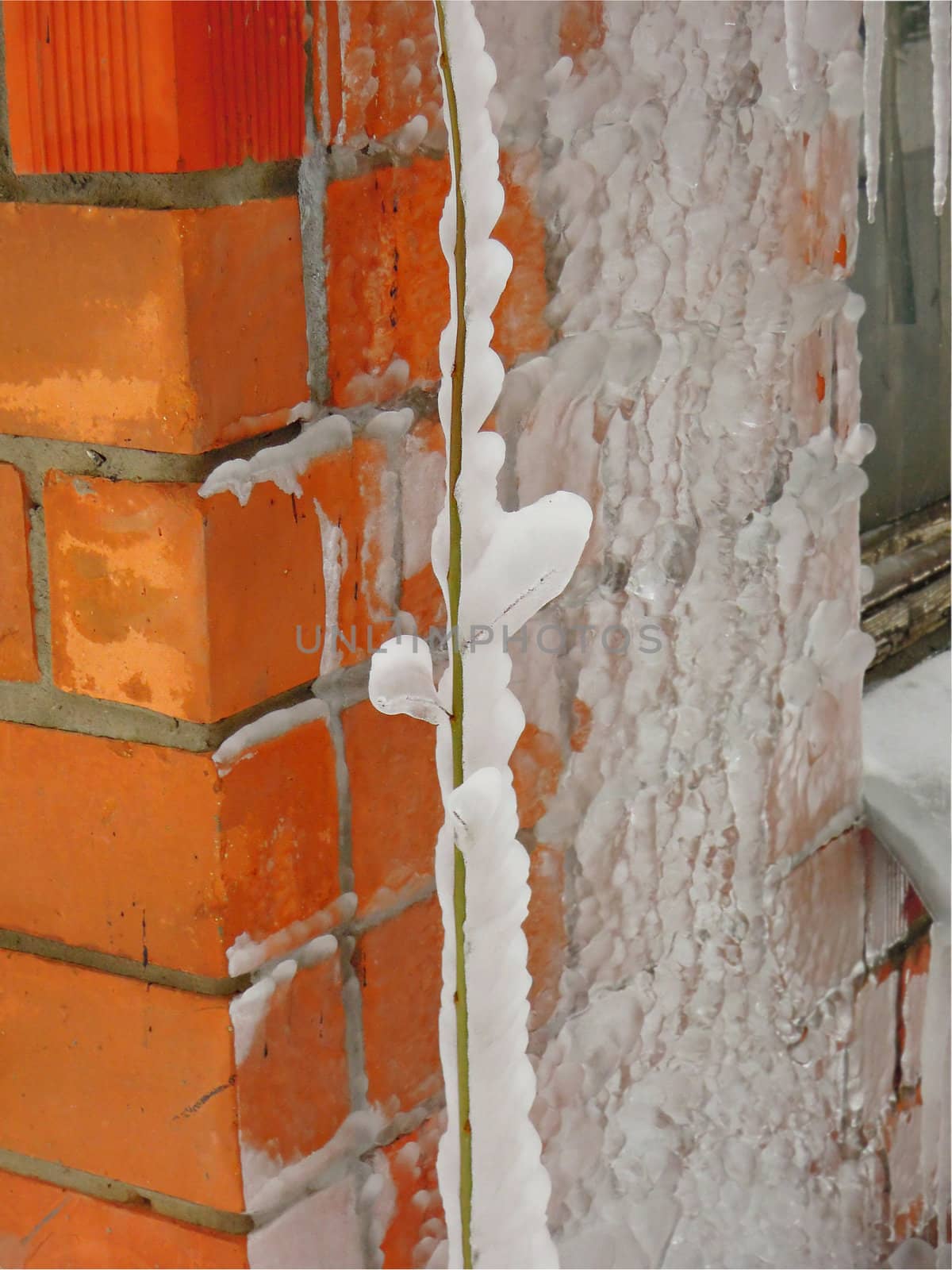 Cold icicle isolated on the background of the wall