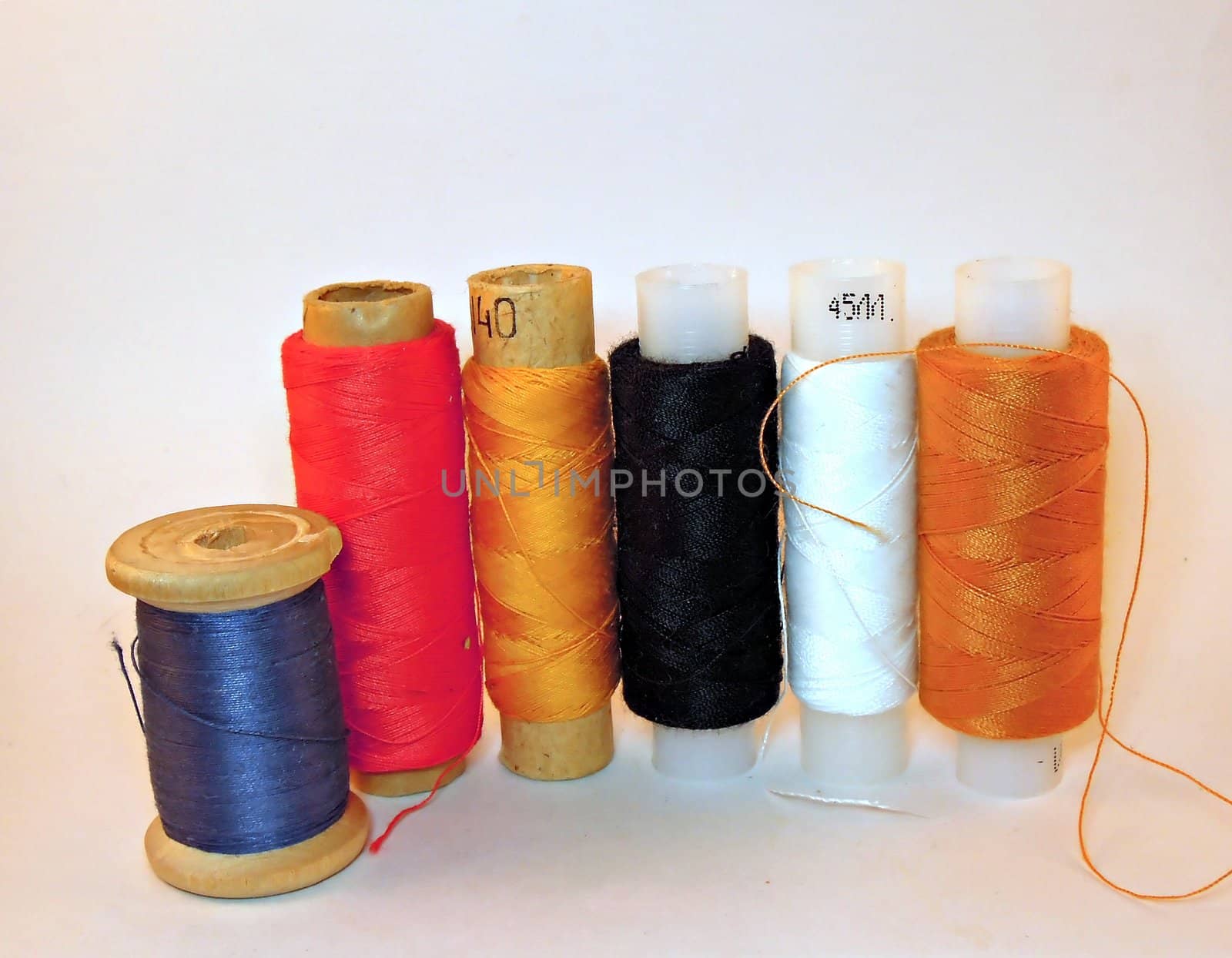 Six reels with some coloured strings and isolated on white background