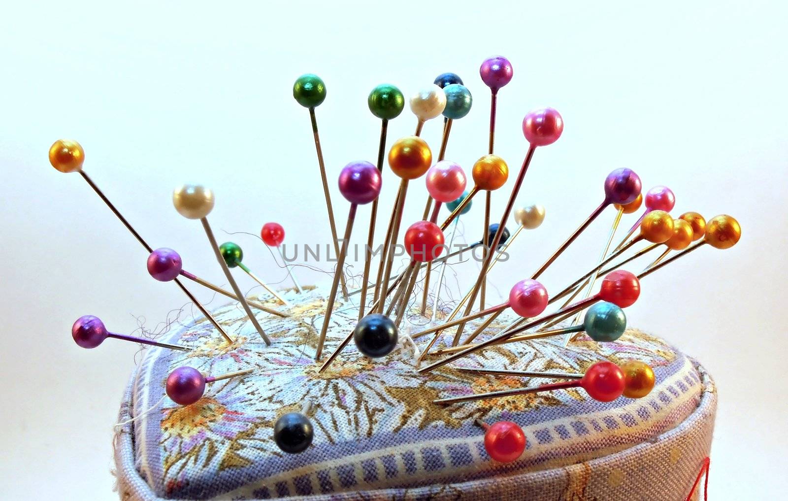 Some needles and they coloured head isolated on white background