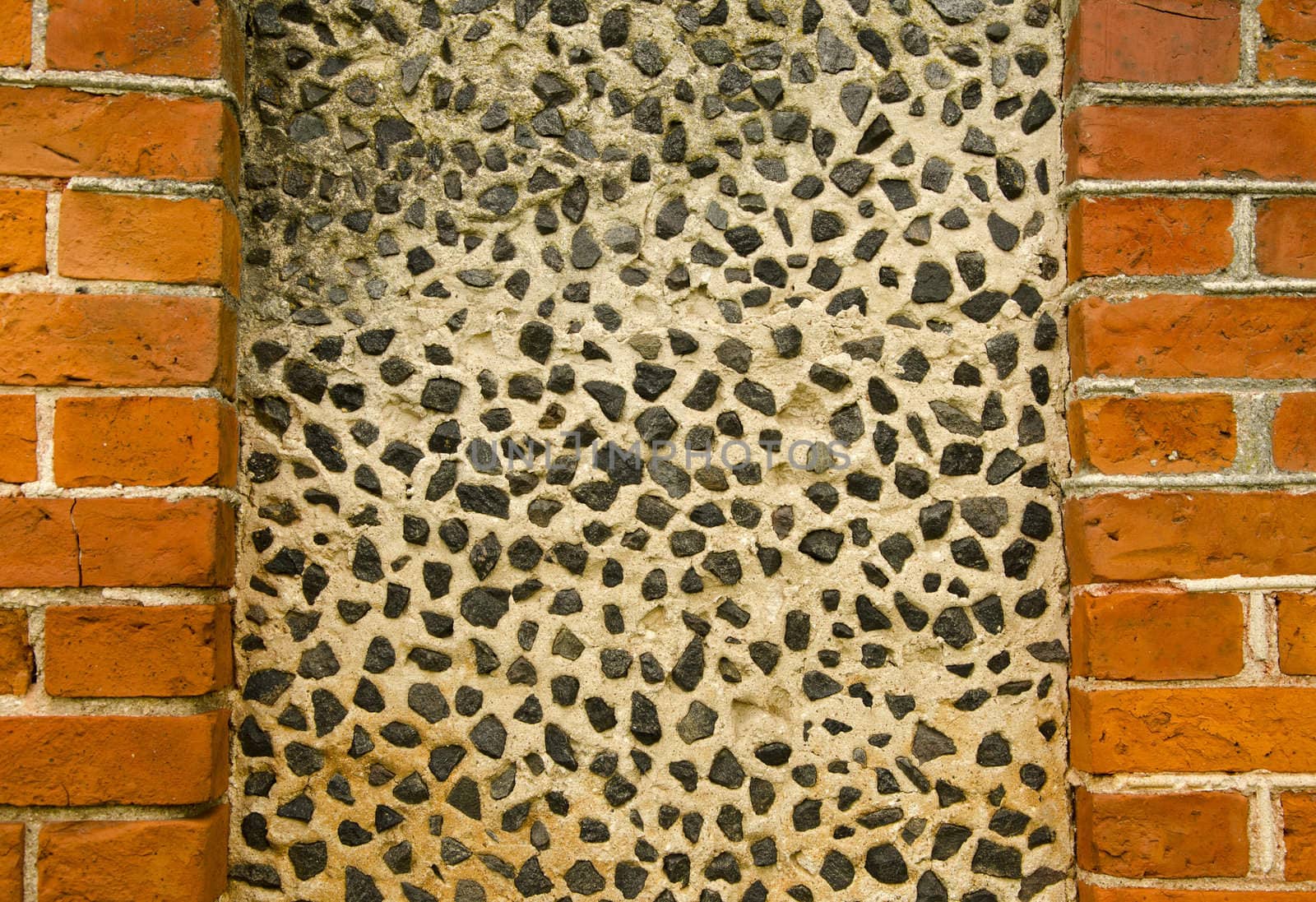 Wall decorated with small pebble stones. Architecture background details.