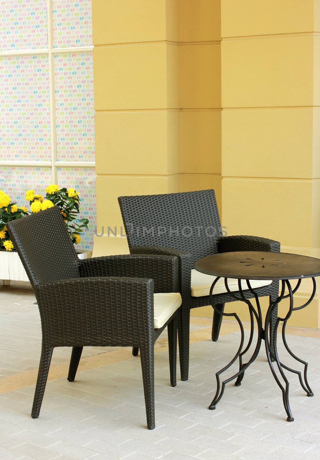 Black table and chair setting with flower in outdoor restaurant by nuchylee