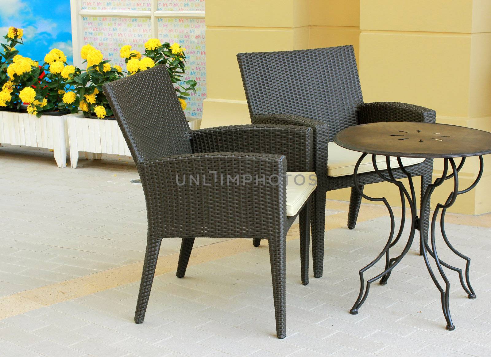 Black table and chair setting with flower in outdoor restaurant by nuchylee