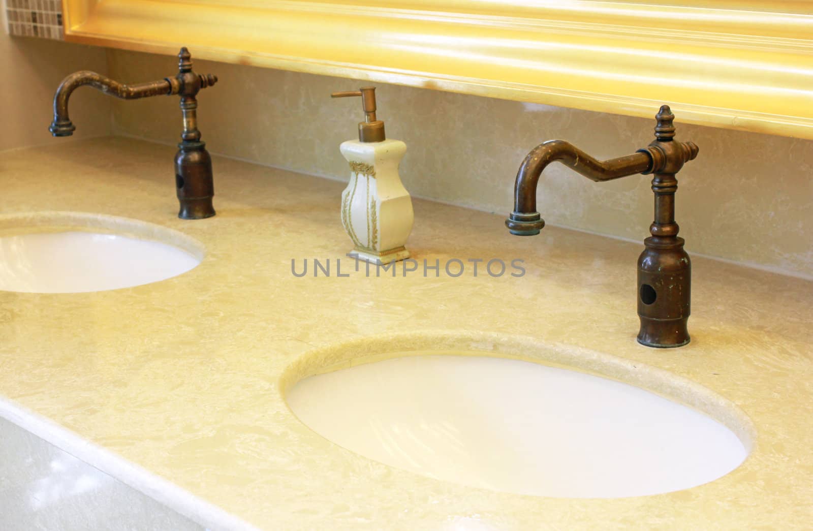 Sinks and taps with hand soap in a public toilet by nuchylee