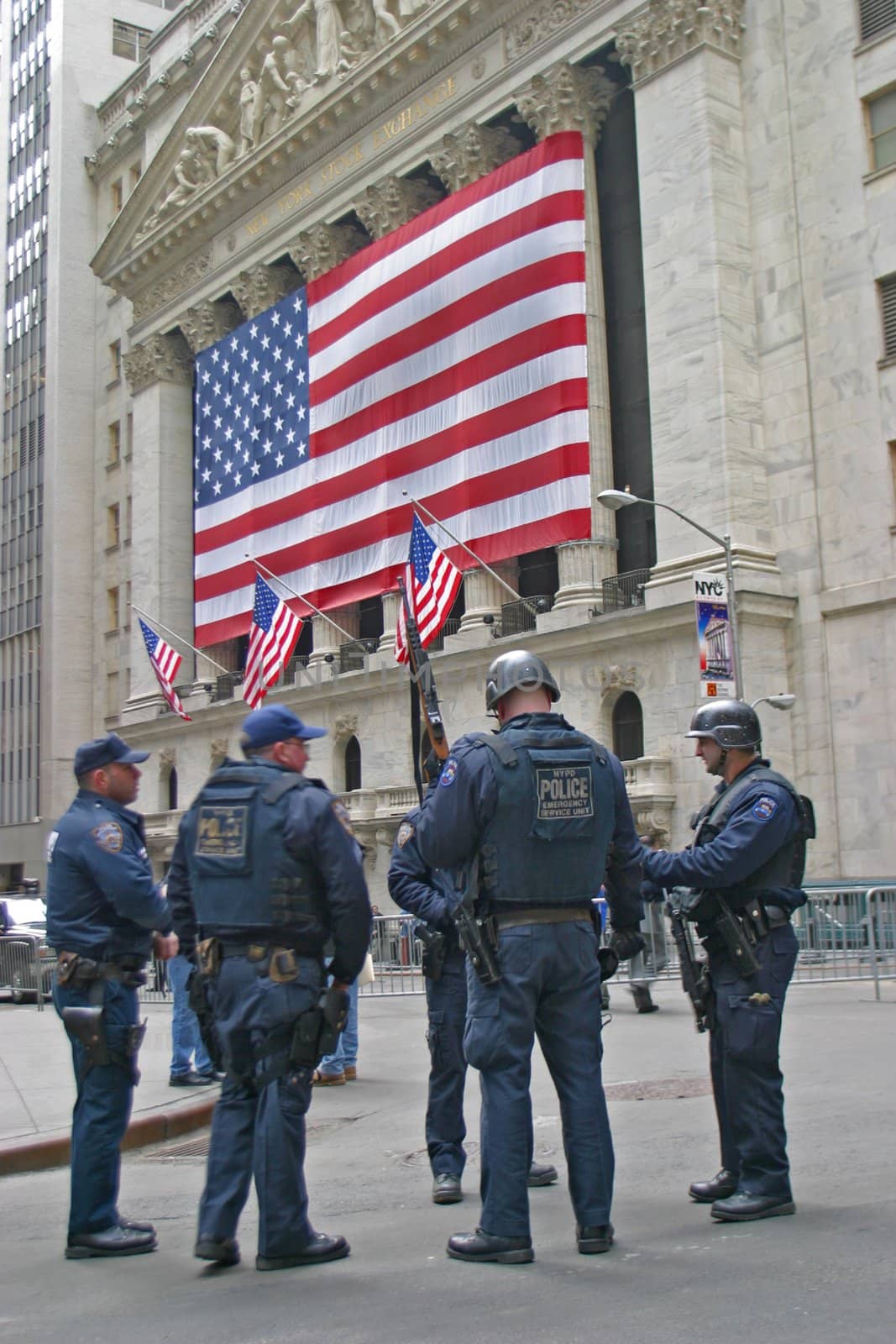 NYPD officers armed with automatic rifles patrol Wall Street, Manhattan, New York