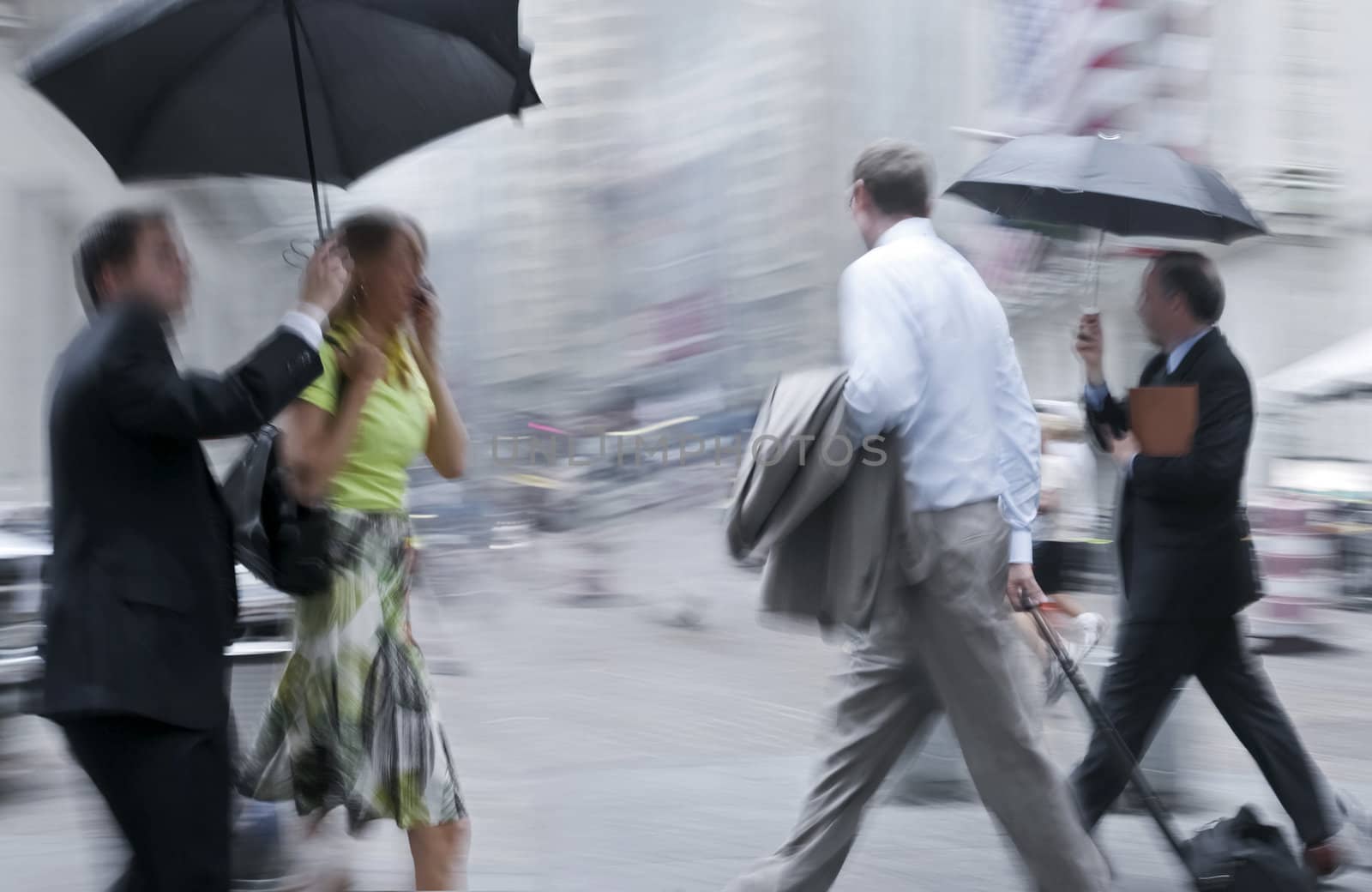 business people rushing on the rainy street in intentional motion blur, intentional blue tint