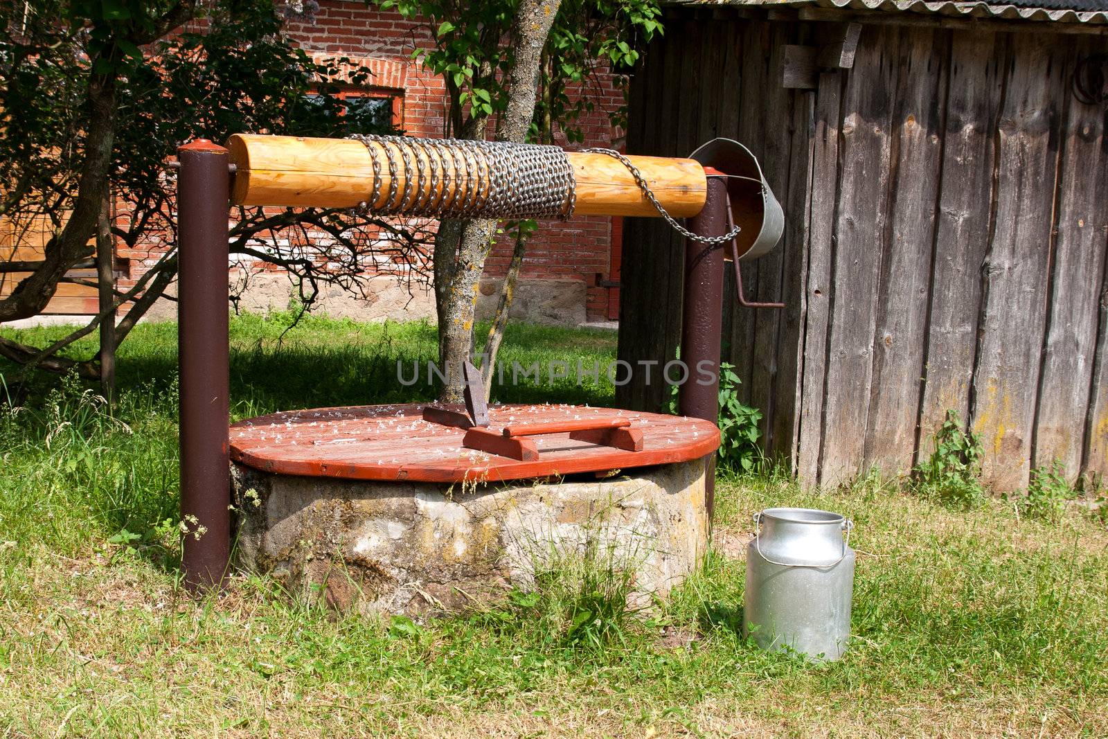 vintage water well and milk canister in the countryside