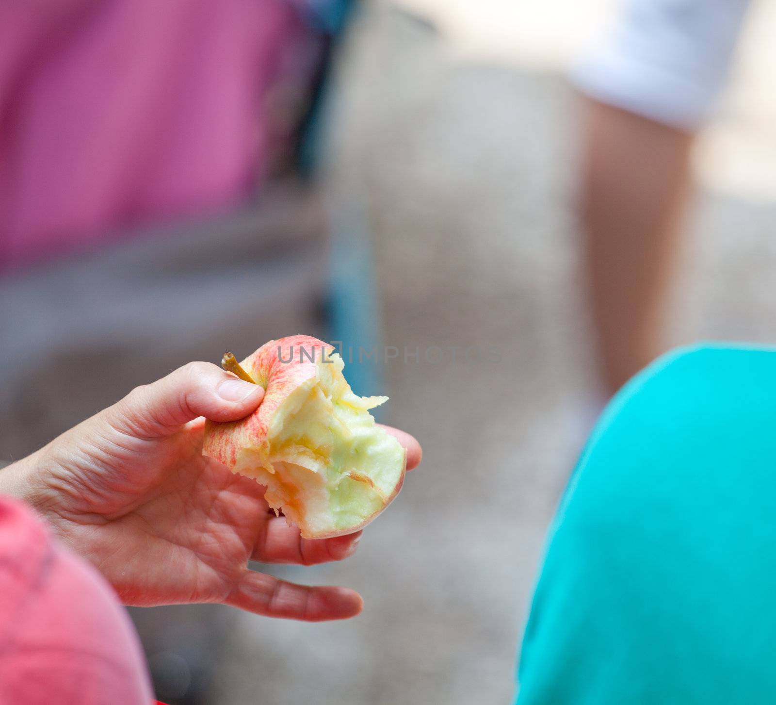 Female holding a red bitten apple