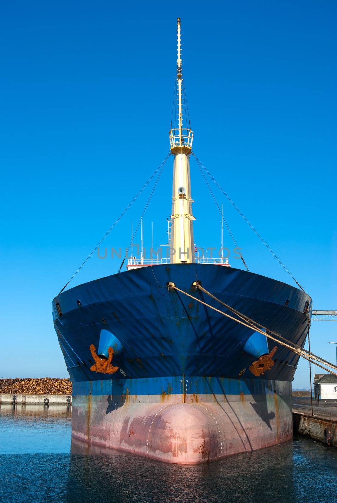 Medium size cargo container ship in the harbor port in frontal view