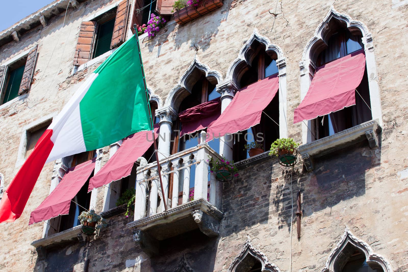 Italian flag flies over a balcony in Venice