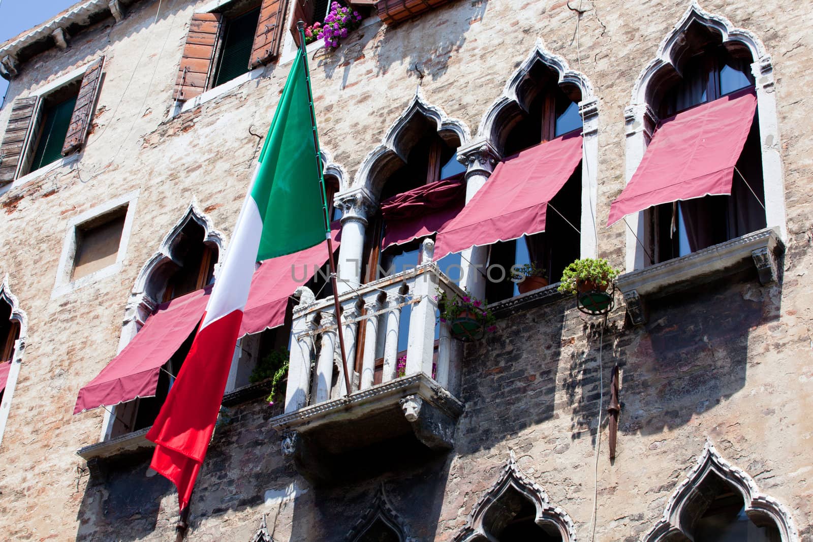 Italian flag flies over a balcony in Venice