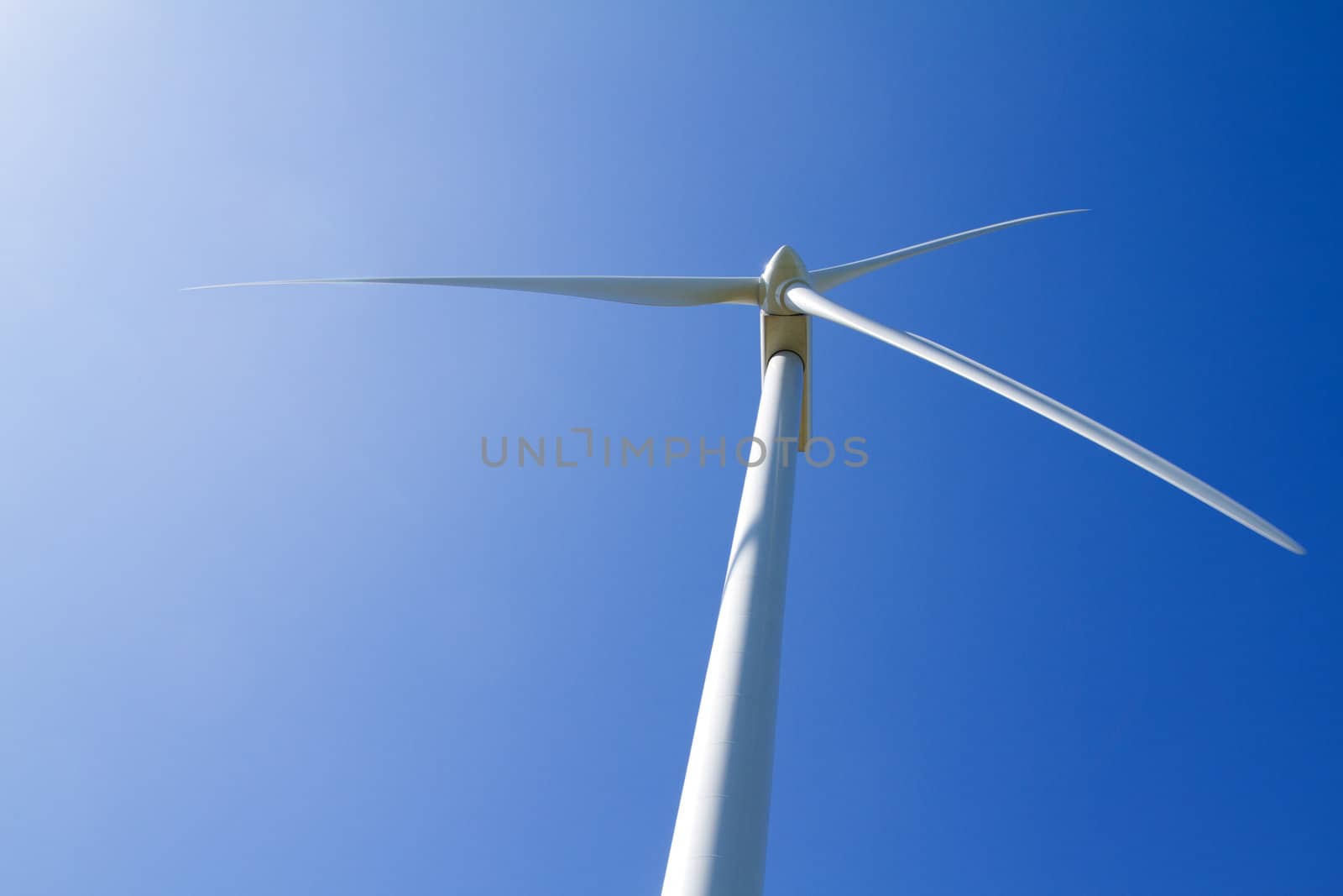 A wind turbine under clear blue sky