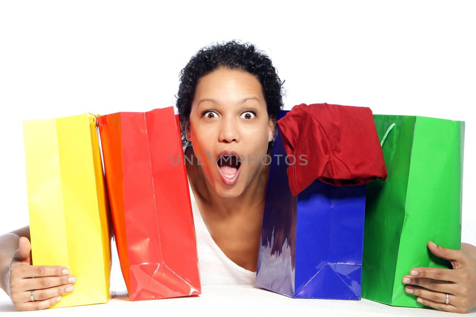 Portrait of shocked woman holding colorful shopping bags
