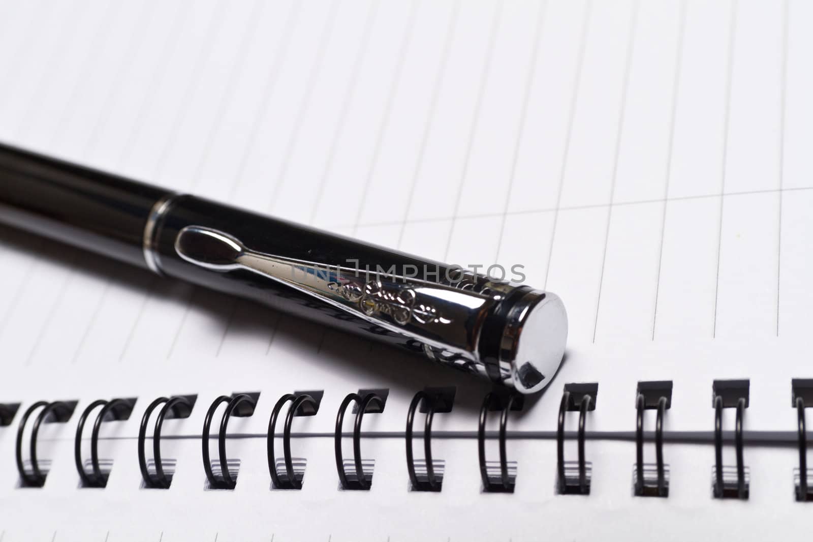 a close up view of an opened note book and a capped pen