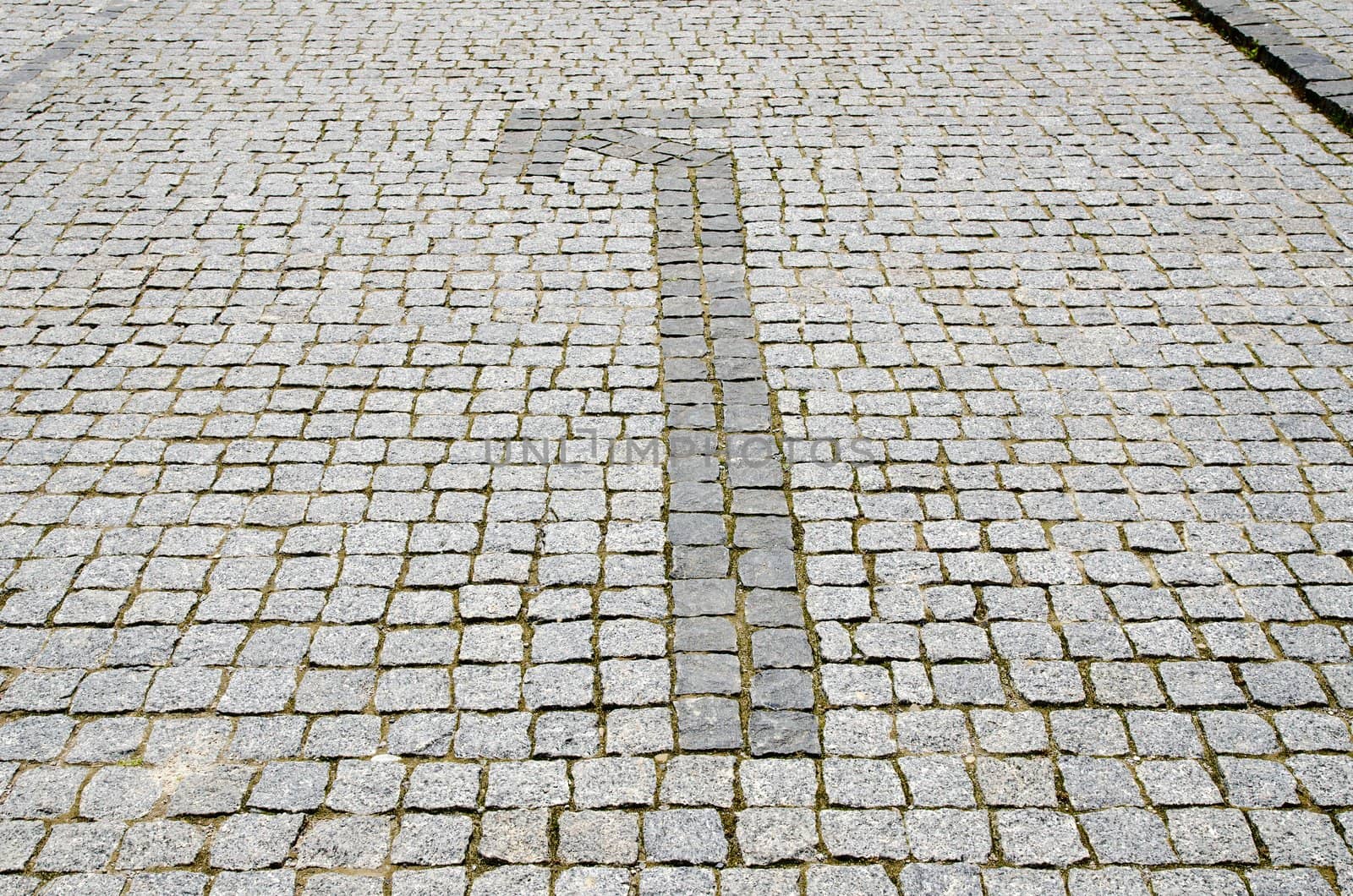 cobbled road with arrow to left