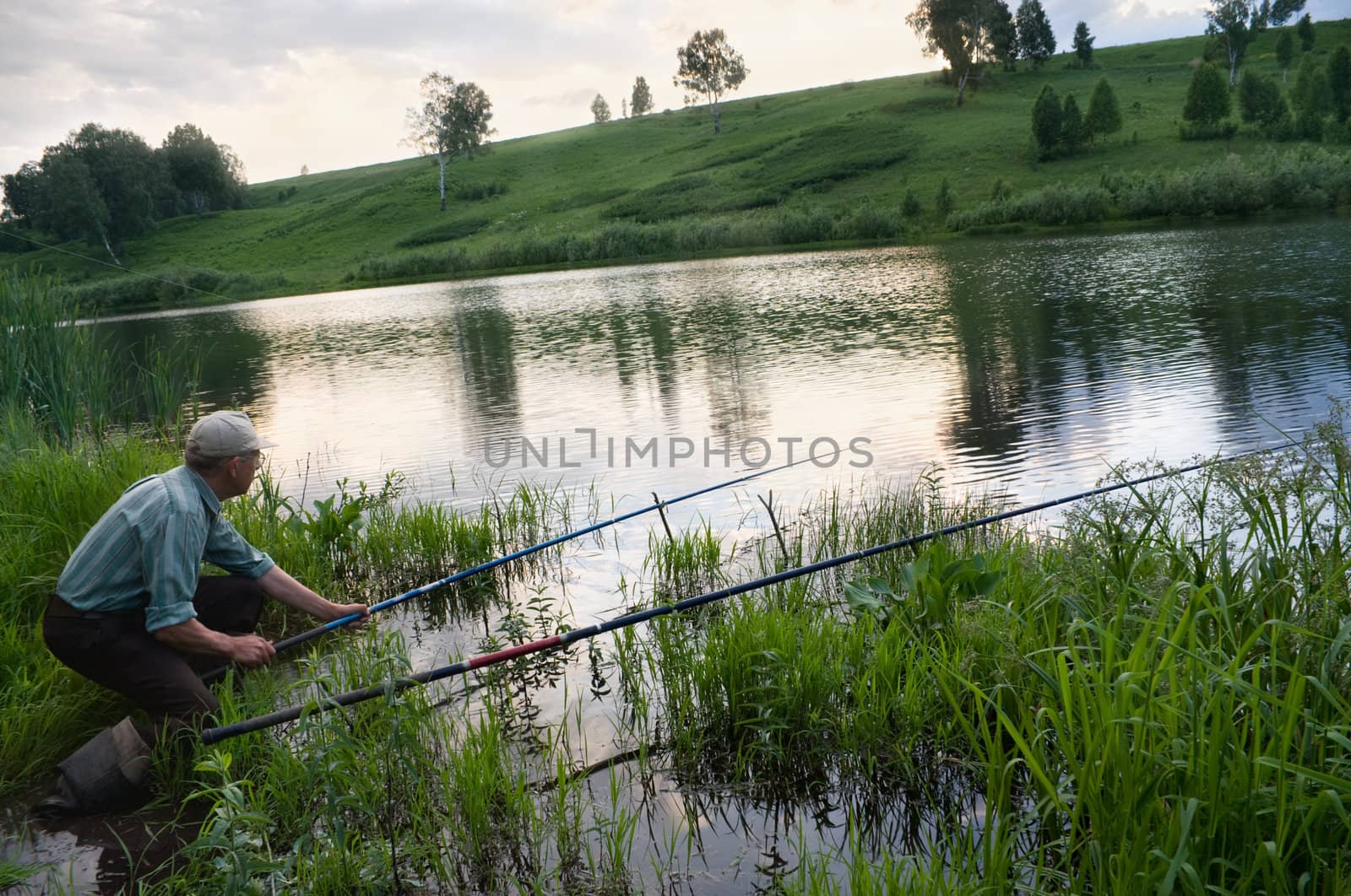 The fisherman catches a fish in the river in the spring