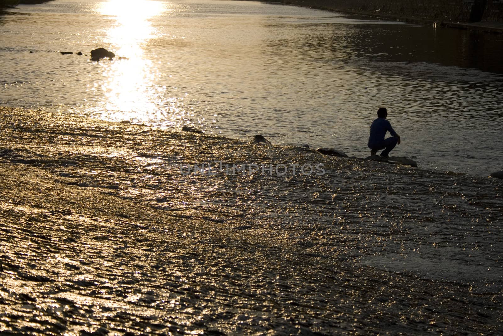 A man on the water, Arno river at sunset, Florence - Italy