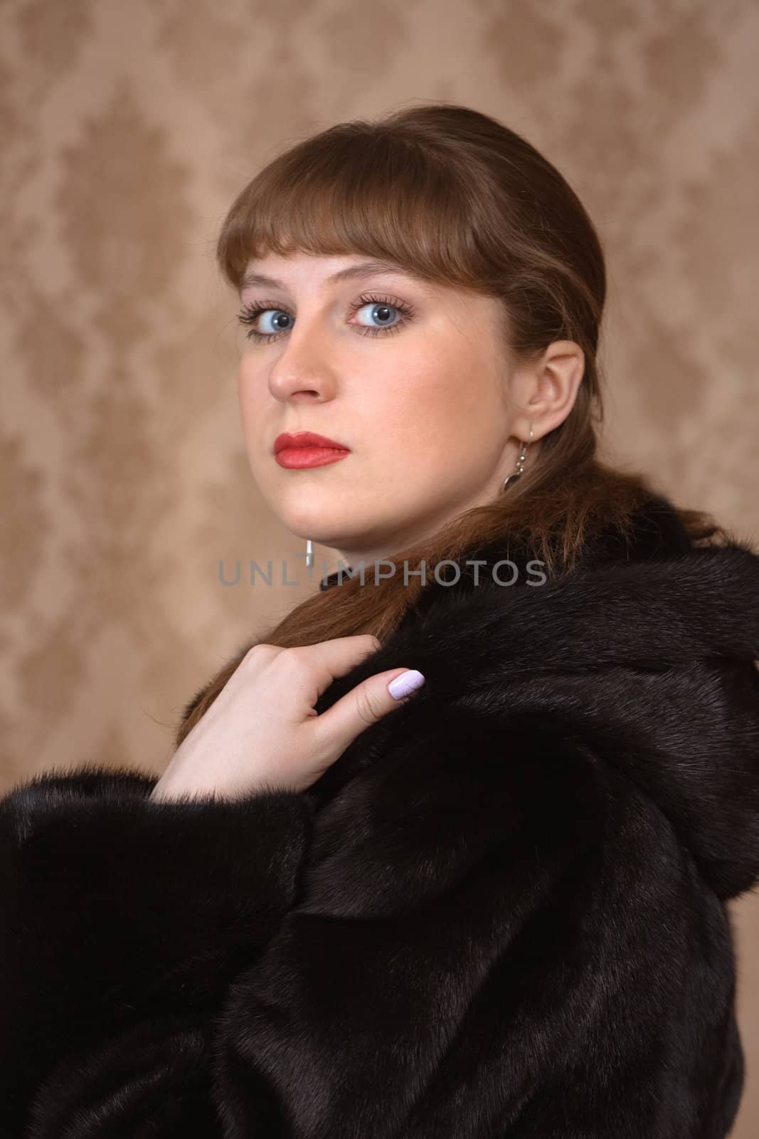 Portrait of the young girl in a black fur coat