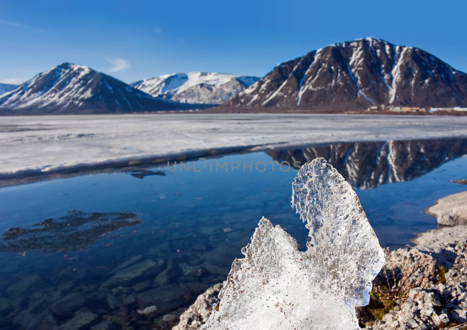 Big piece of ice on coast of lake in mountains