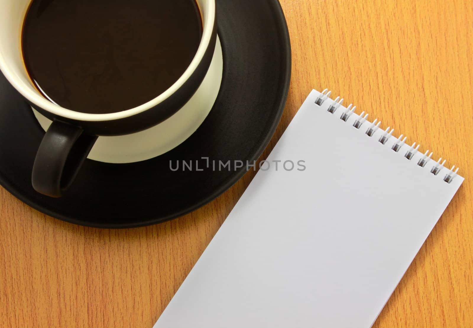 Coffee cup and white notebook