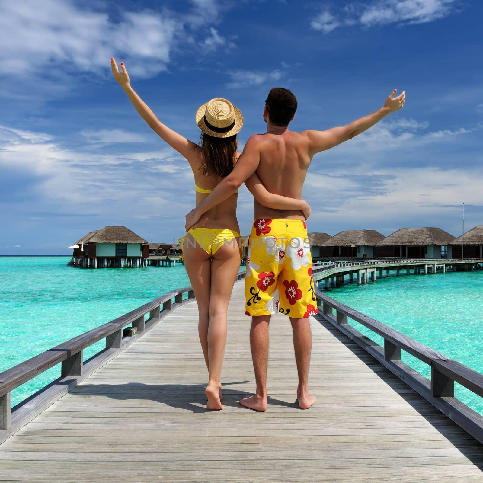 Couple on a tropical beach jetty at Maldives