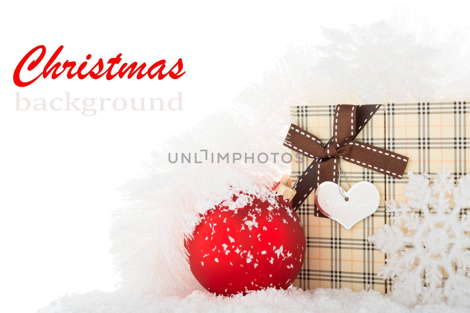 Gift box and Christmas tree decorations on a snow.