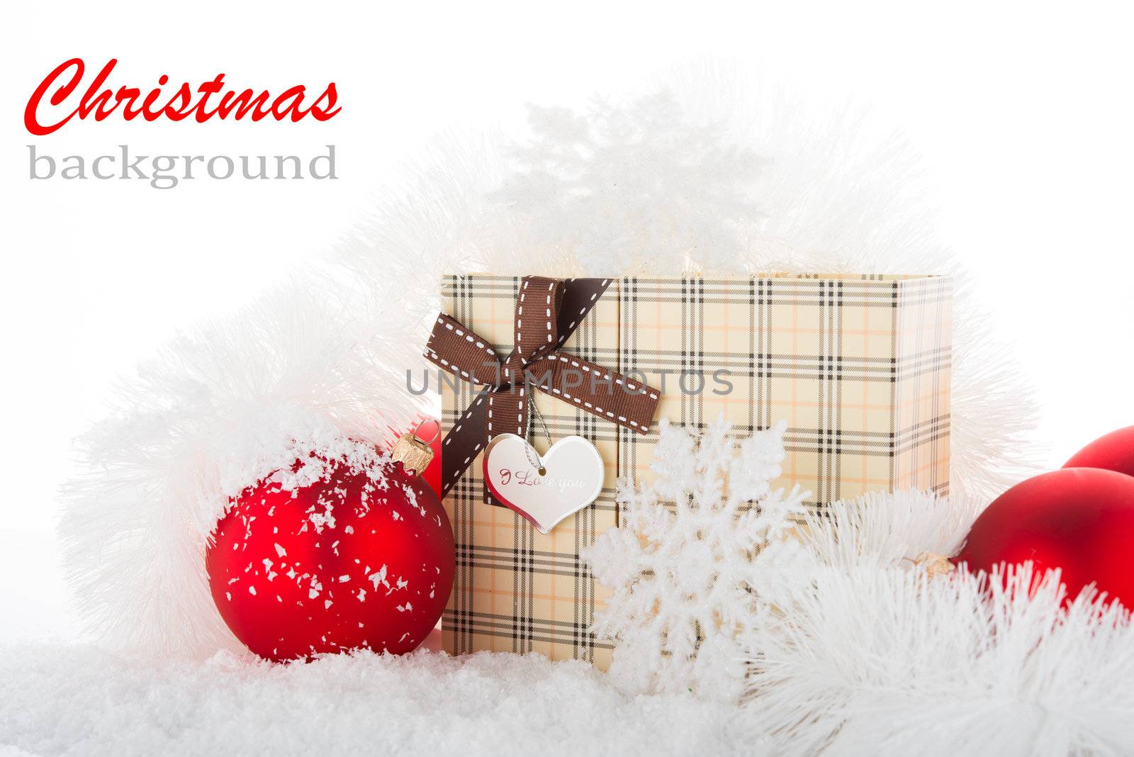 Gift box and Christmas tree decorations on a snow.
