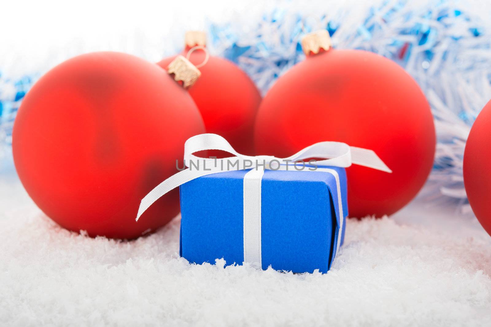 Gift box and Christmas tree decorations on a snow.