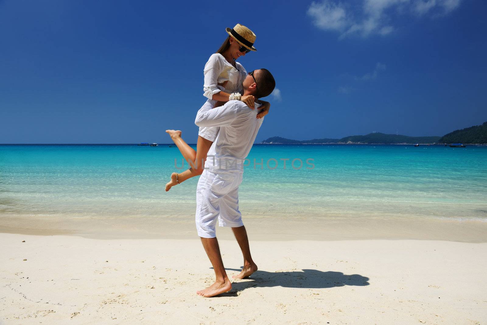 Couple in white on a beach by haveseen