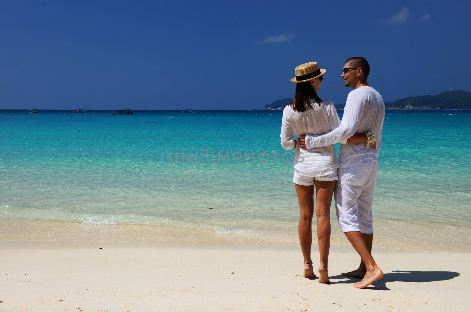 Couple in white on a beach by haveseen