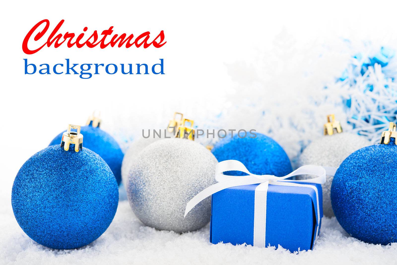 Gift box and Christmas tree decorations on a snow.