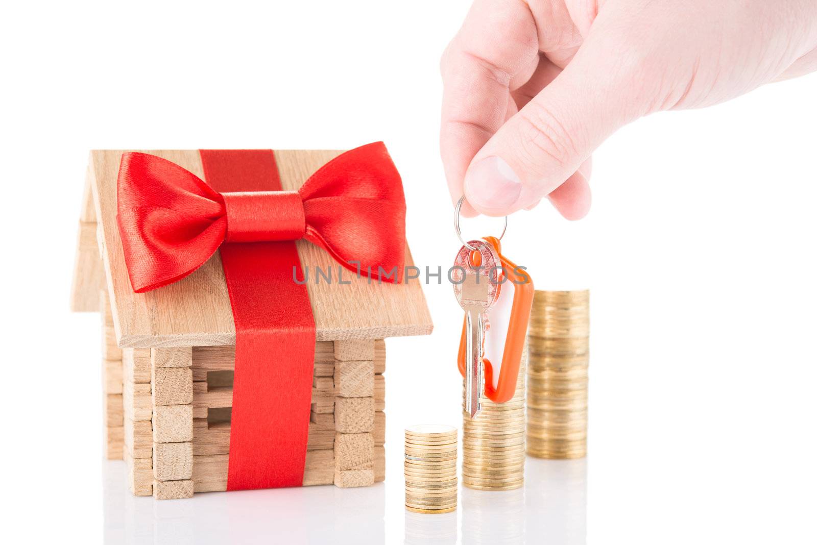 Concept of mortgage with keysin a hand and wooden house