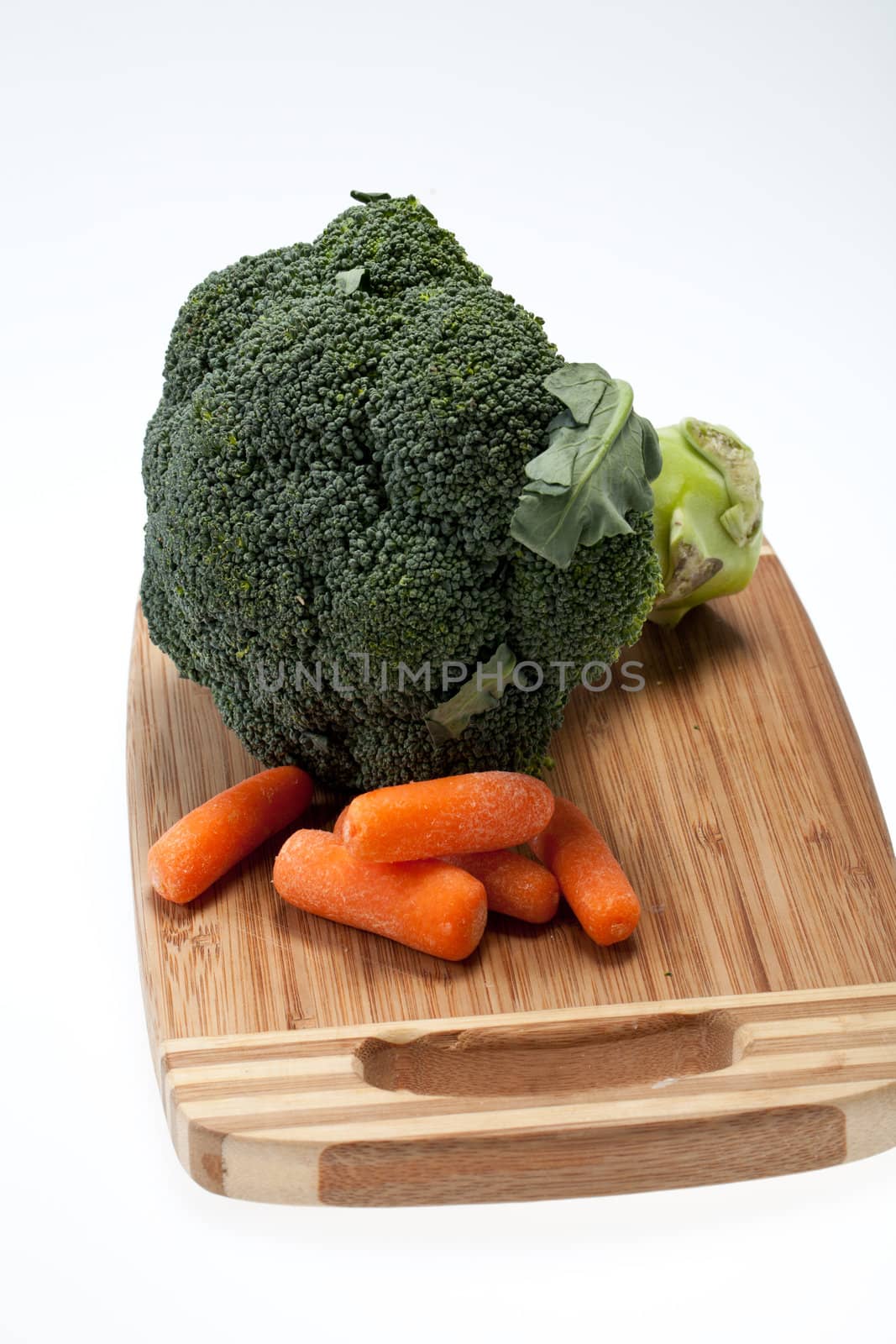brocolli and carrots on the cutting board on the white background 